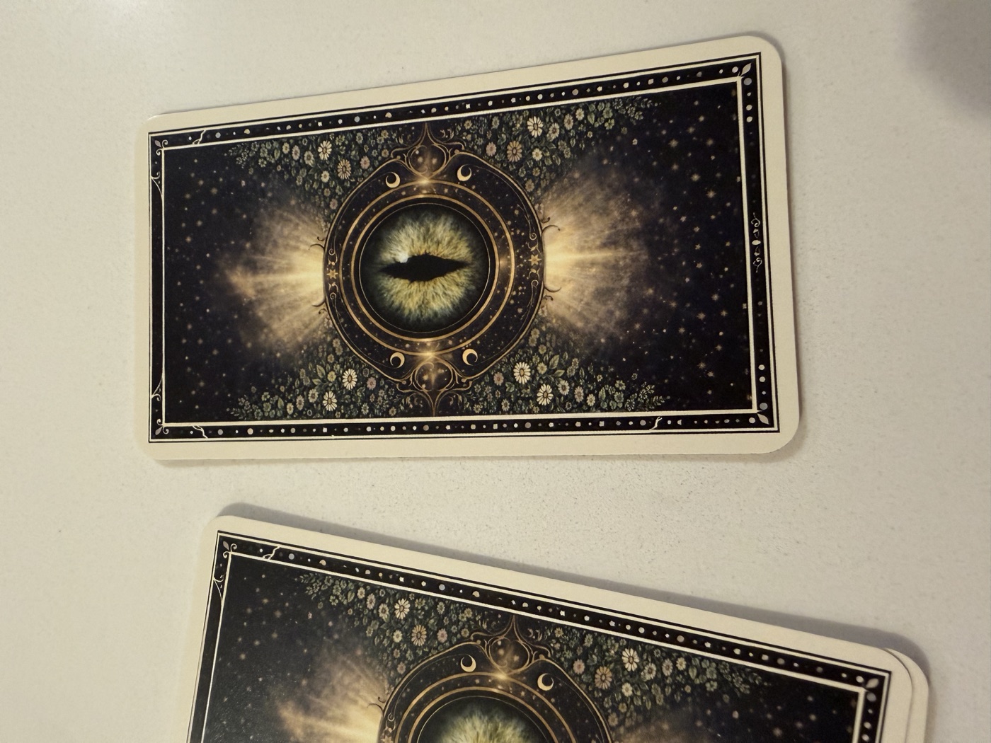 Close-up of the printed tarot deck card backs with a celestial cat-eye design