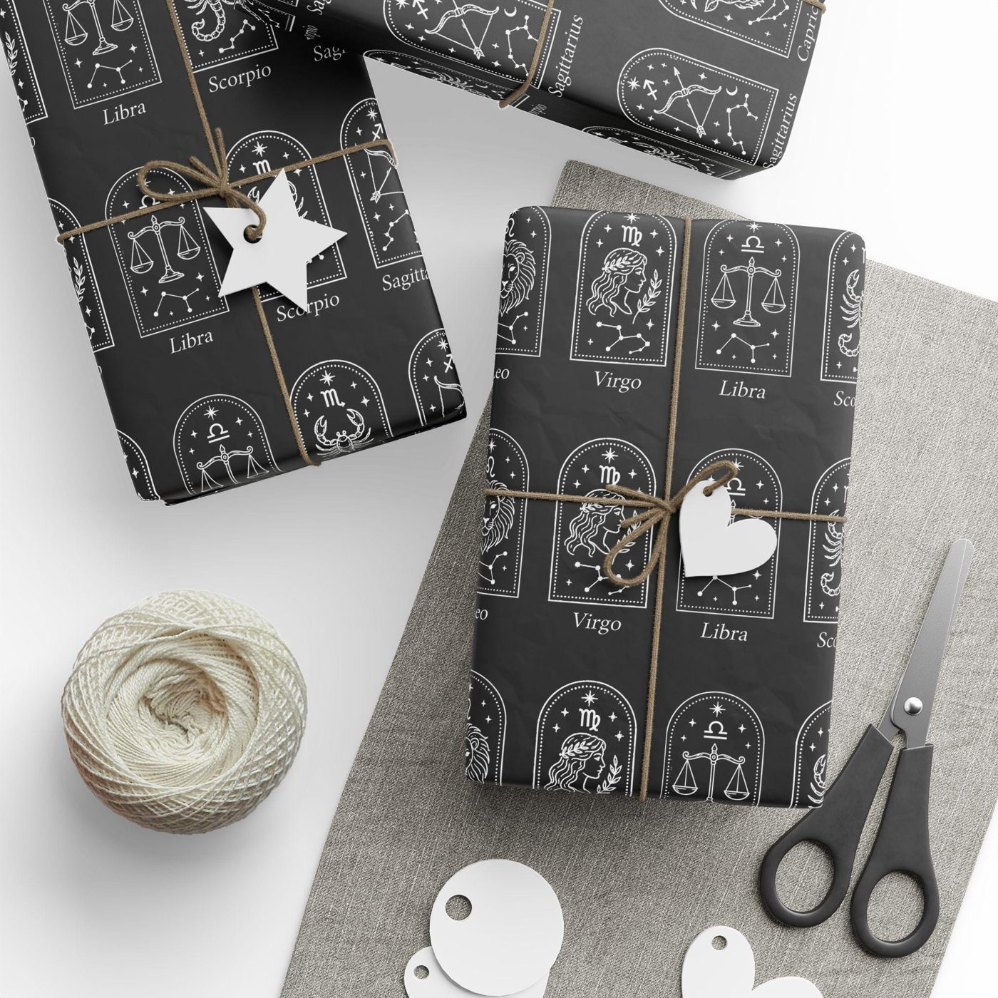 Black wrapping paper printed with twelve white zodiac constellation arches, each named